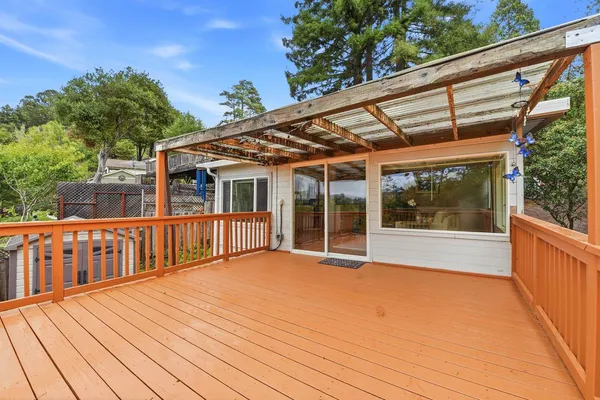 a view of backyard with deck and outdoor seating
