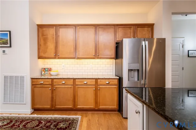 a kitchen with stainless steel appliances granite countertop a refrigerator and a stove