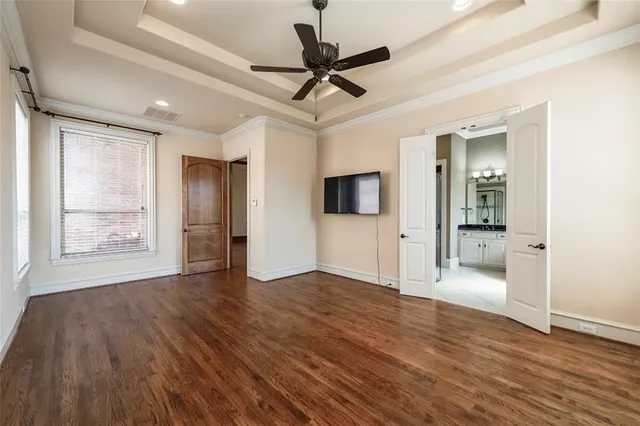 a view of empty room with wooden floor and a ceiling fan