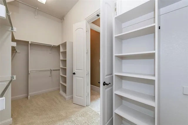 a view of walk in closet with empty racks
