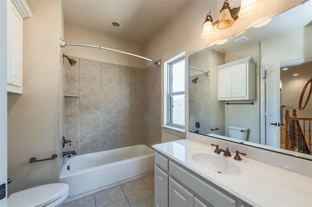 a bathroom with a sink double vanity mirror bathtub and toilet