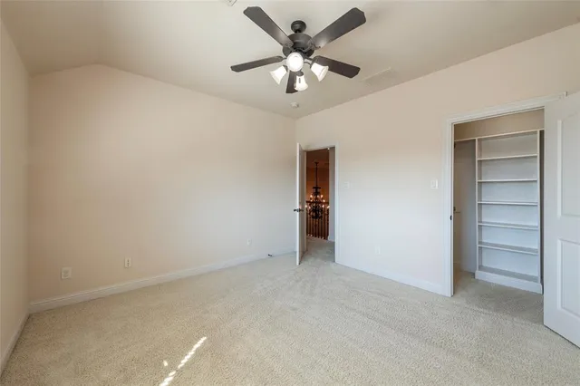 a view of an empty room with a ceiling fan