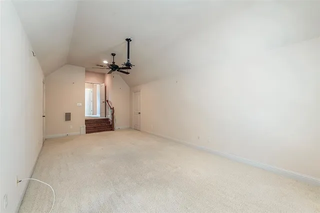 an empty room with a ceiling fan and window