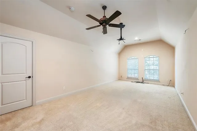 an empty room with a ceiling fan and window
