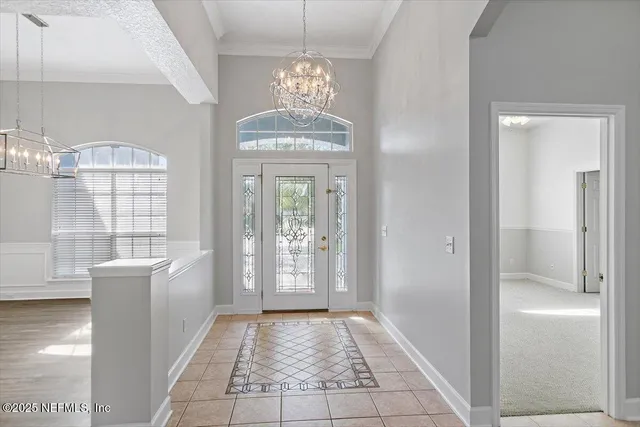 a view of a hallway with windows and chandelier