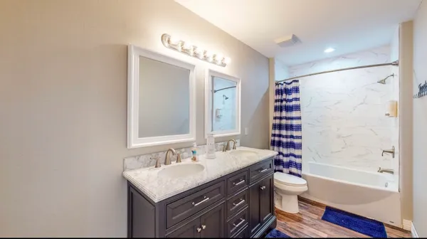 a bathroom with a sink toilet double vanity and bathtub