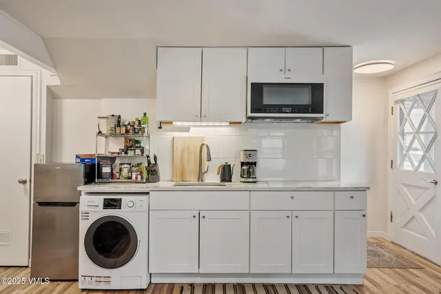 a kitchen with white cabinets and stainless steel appliances