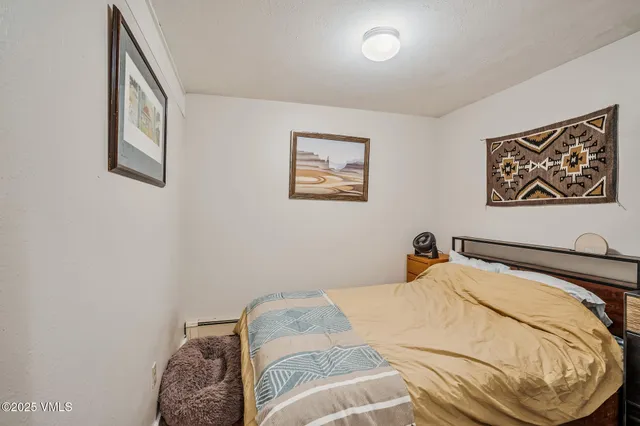 a bedroom with a bed and a painting on the wall