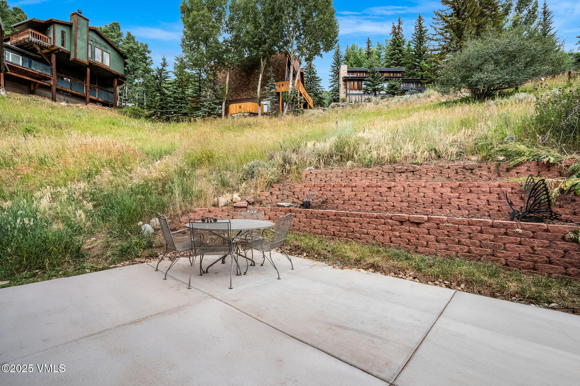 2487 Chamonix Lane, Unit F1 Vail, CO 81657 - Photo 22 of 27 a view of a patio with chairs and a yard