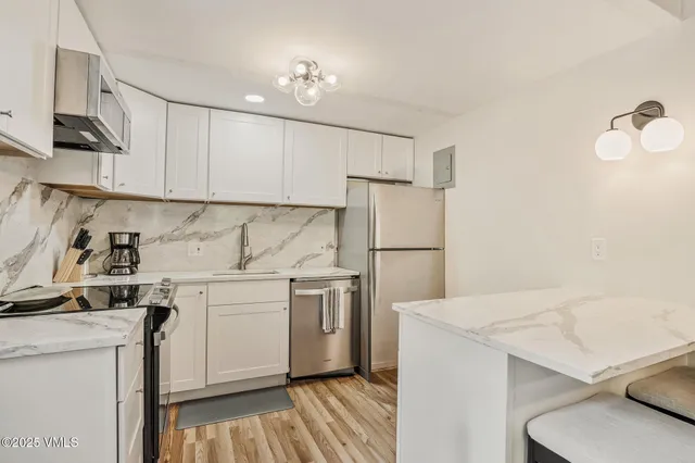 a kitchen with a sink a refrigerator and cabinets