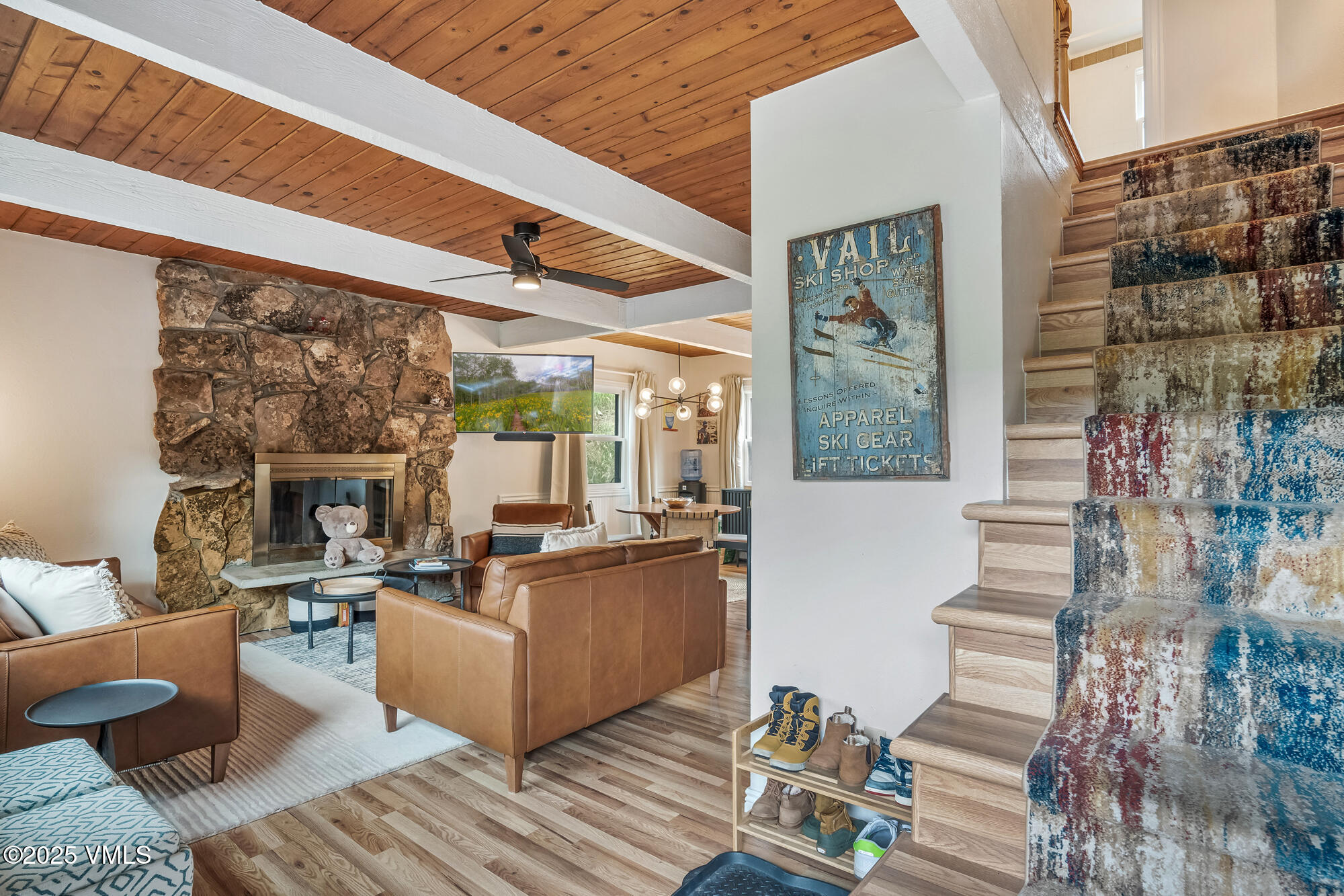 2487 Chamonix Lane, Unit F1 Vail, CO 81657 - Photo 8 of 27 a living room with couches a fireplace and kitchen view with wooden floor