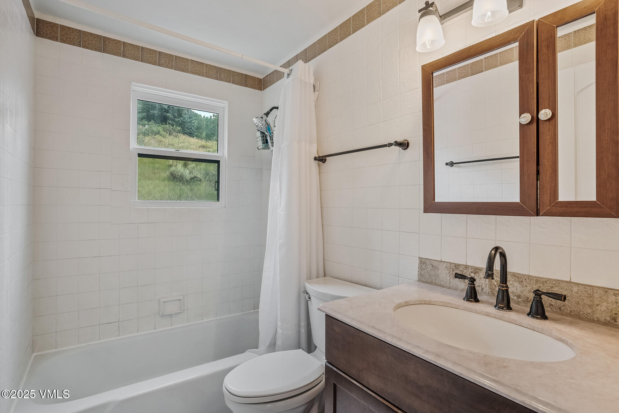 2487 Chamonix Lane, Unit F1 Vail, CO 81657 - Photo 10 of 27 a bathroom with a granite countertop sink toilet a mirror and shower