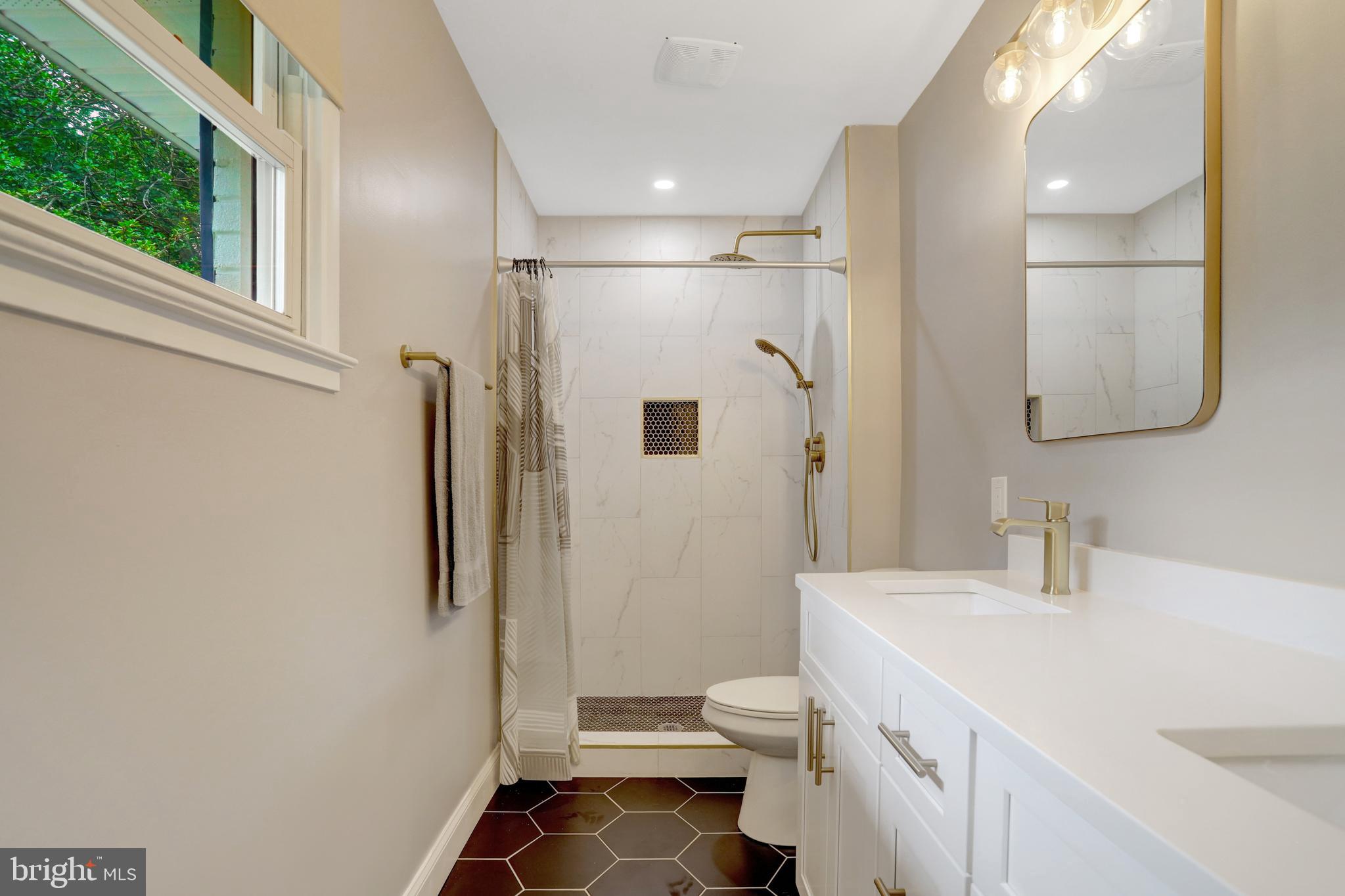 5418 Inverchapel Road Springfield, VA 22151 - Photo 23 of 94 a bathroom with a sink a toilet a large mirror and shower