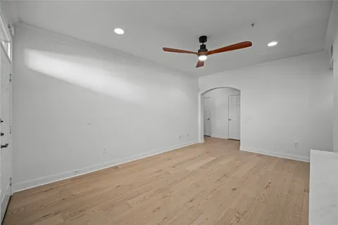 an empty room with a ceiling fan and window
