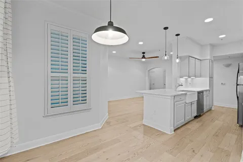 a large white kitchen with a sink a refrigerator and a stove