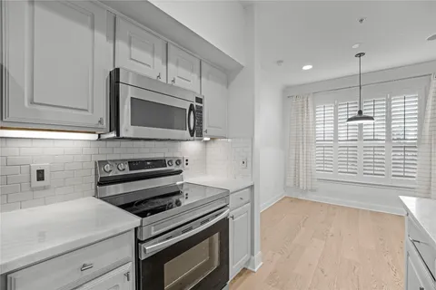 a kitchen with stainless steel appliances a stove microwave and sink