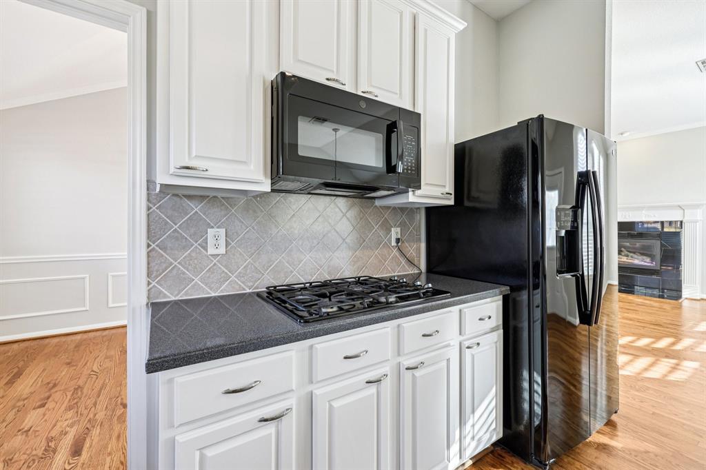 7313 San Carlos Drive Rowlett, TX 75089 - Photo 19 of 40 a kitchen with stainless steel appliances granite countertop a stove a refrigerator and a microwave