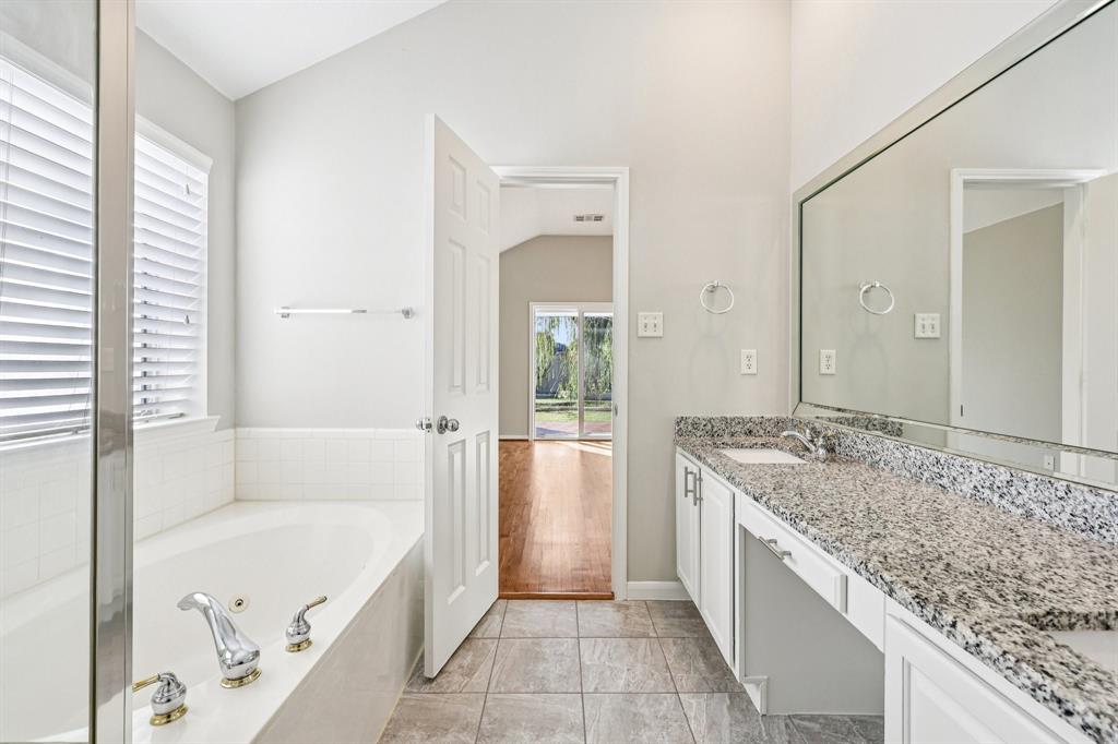 7313 San Carlos Drive Rowlett, TX 75089 - Photo 25 of 40 a bathroom with a granite countertop tub sink and mirror