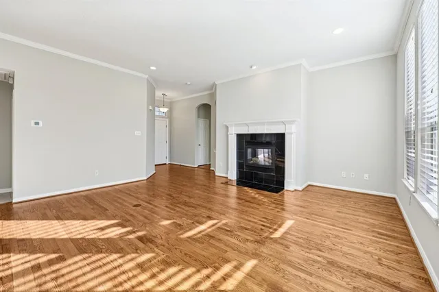 a view of empty room with wooden floor and fireplace