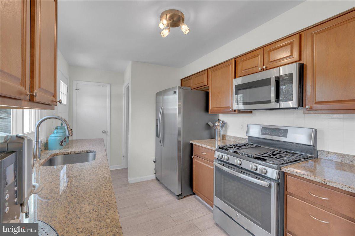 166 Sproul Road Malvern, PA 19355 - Photo 5 of 20 a kitchen with stainless steel appliances granite countertop a stove microwave and sink