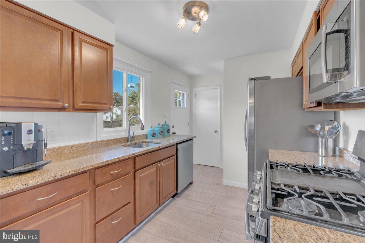 166 Sproul Road Malvern, PA 19355 - Photo 6 of 20 a kitchen with stainless steel appliances granite countertop a sink stove and refrigerator