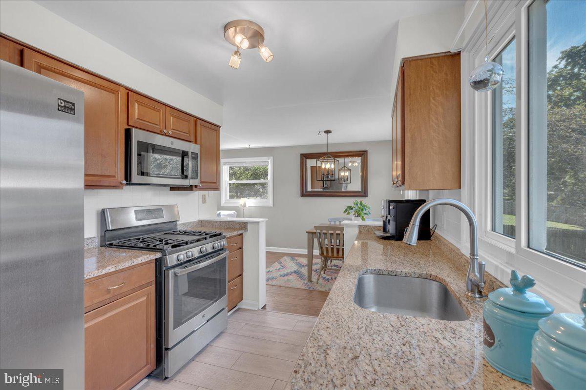 166 Sproul Road Malvern, PA 19355 - Photo 7 of 20 a kitchen with stainless steel appliances granite countertop a stove top oven a sink a dining table and chairs