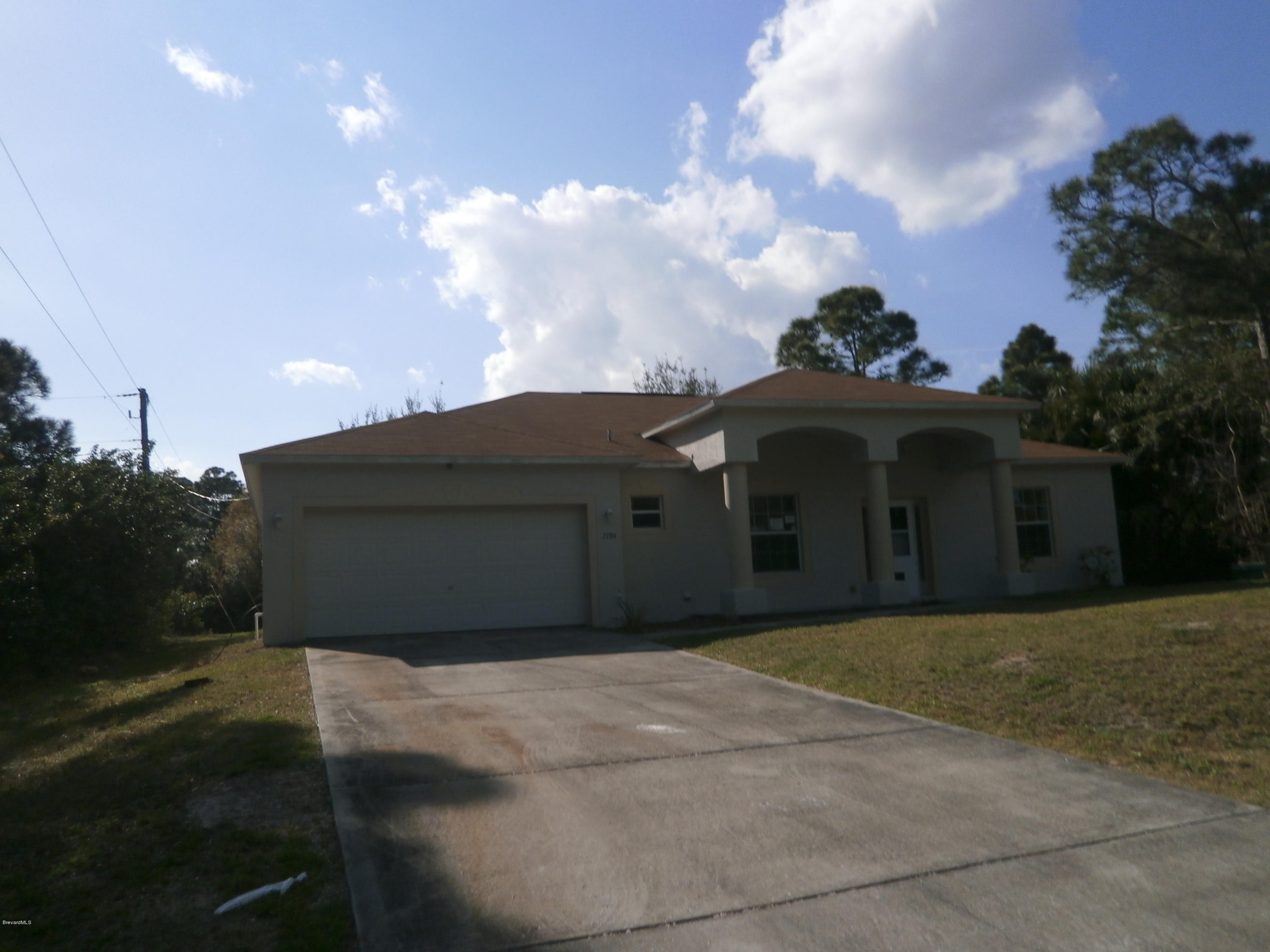 2784 Digby Road Southeast Palm Bay, FL 32909 - Photo 1 of 19 a front view of a house with a yard