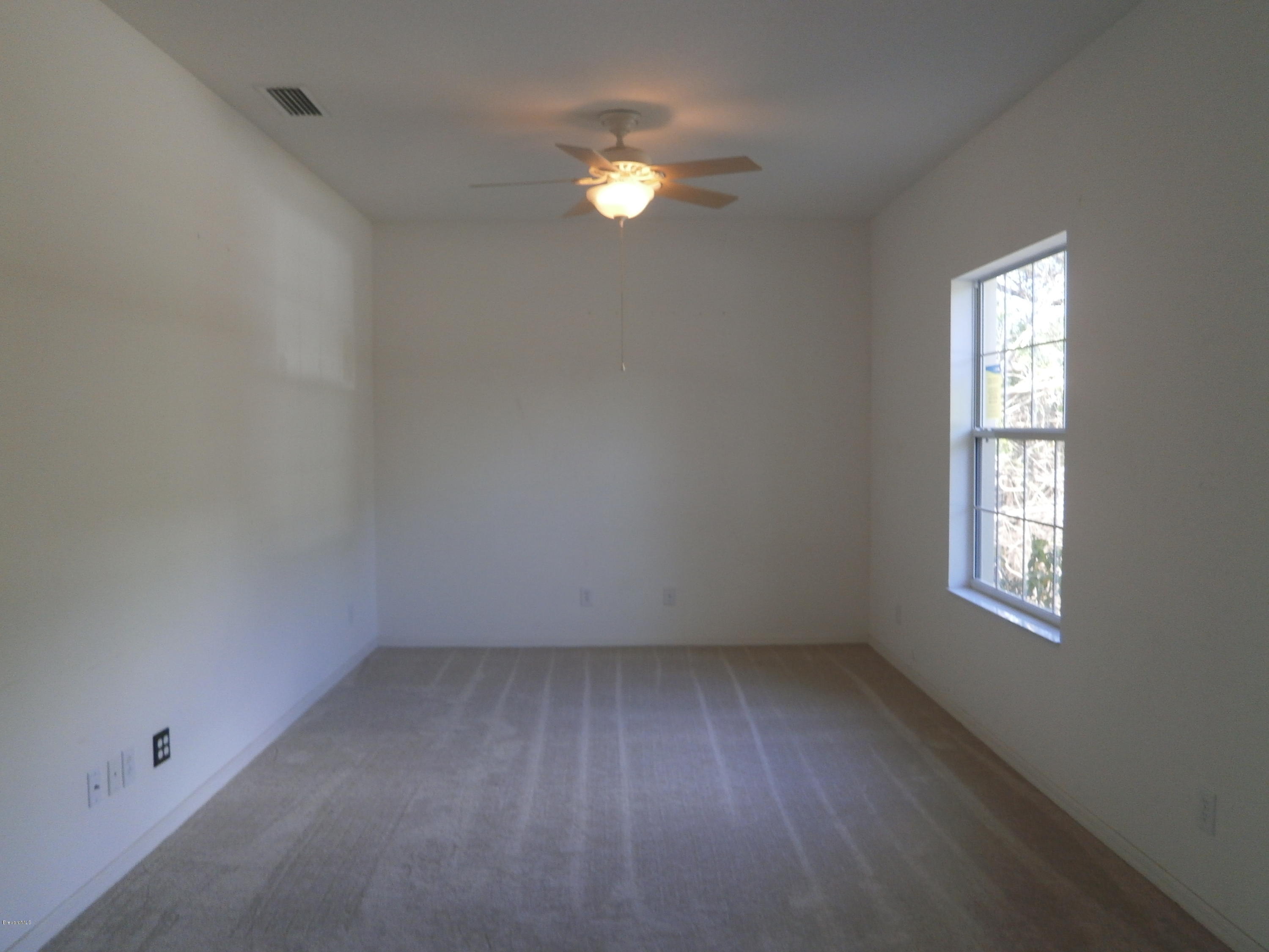 2784 Digby Road Southeast Palm Bay, FL 32909 - Photo 14 of 19 an empty room with a window and a fan