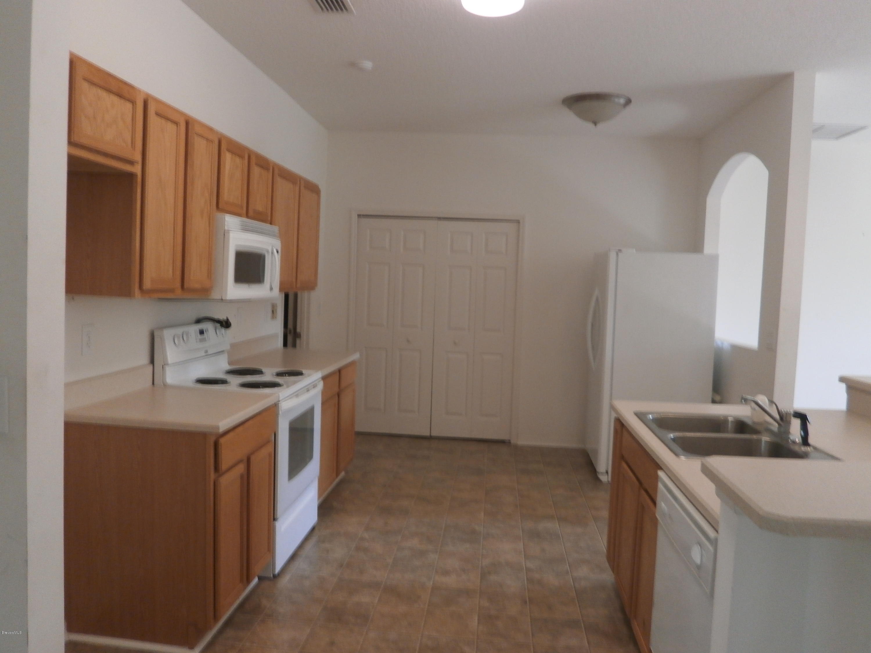 2784 Digby Road Southeast Palm Bay, FL 32909 - Photo 4 of 19 a kitchen with a sink stove and cabinets