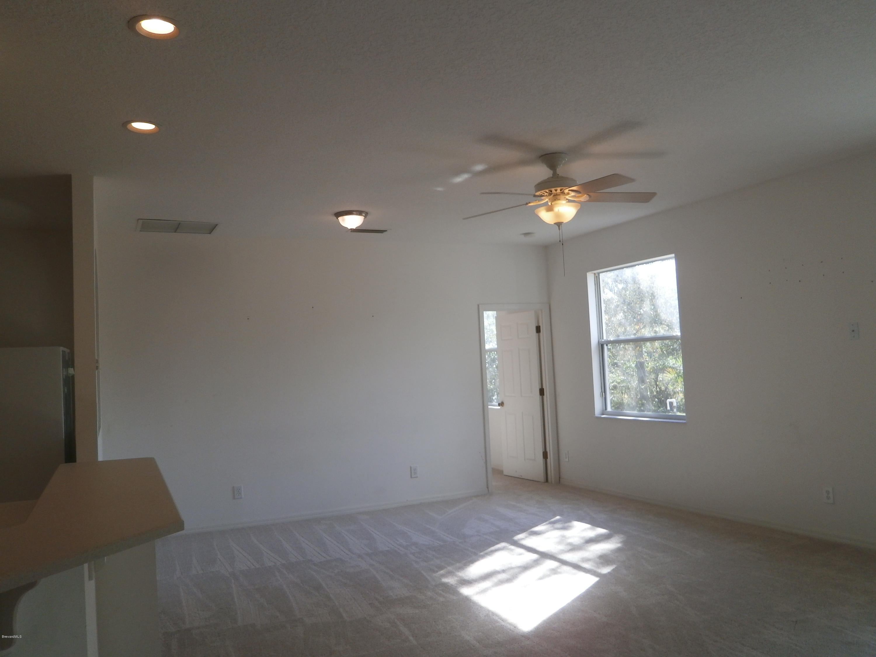 2784 Digby Road Southeast Palm Bay, FL 32909 - Photo 10 of 19 a view of an empty room and window and chandelier fan