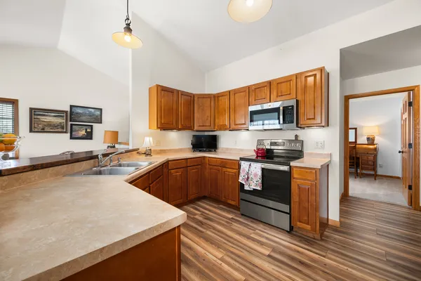 a kitchen with stainless steel appliances a stove a sink a center island and a refrigerator