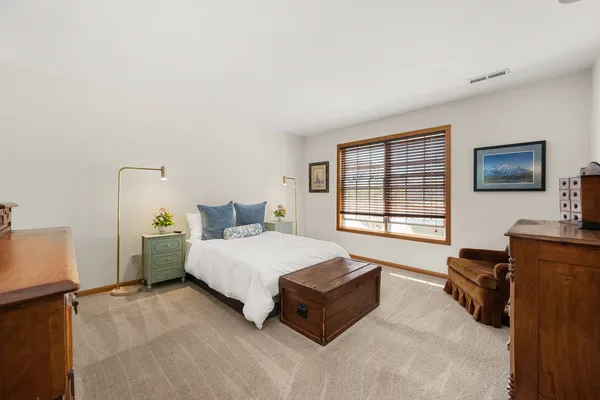 a spacious bedroom with a bed and a large window