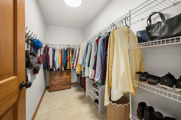 a view of walk in closet with clothes and shoes