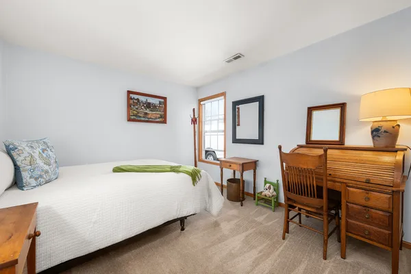 a bedroom with a bed a desk and chair