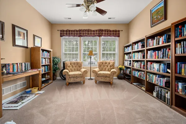 a living room with furniture and a book shelf