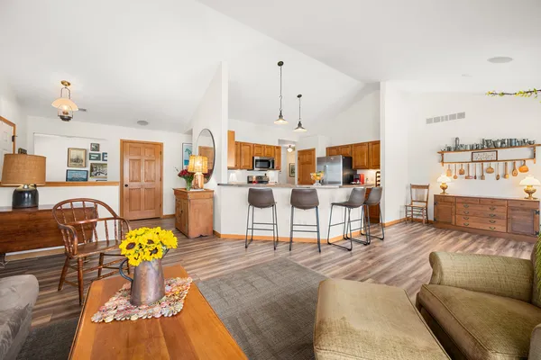 a living room with furniture kitchen view and a chandelier