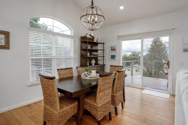 a dining room with furniture a chandelier and wooden floor