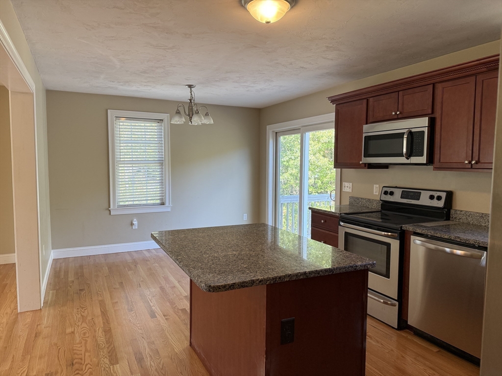 87 Center Street Carver, MA 02330 - Photo 11 of 42 a kitchen with a sink a microwave a stove and refrigerator