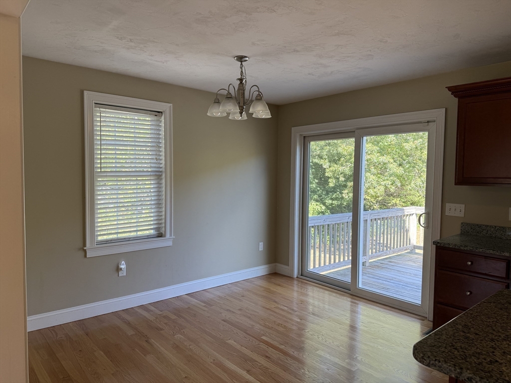87 Center Street Carver, MA 02330 - Photo 12 of 42 a view of an empty room with a window and wooden floor