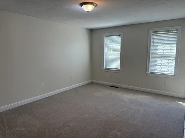 an empty room with windows and mirror