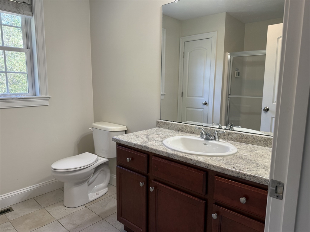 87 Center Street Carver, MA 02330 - Photo 22 of 42 a bathroom with a granite countertop toilet a sink and a mirror
