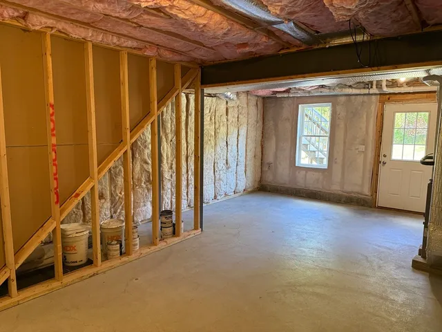 a view of an empty room with wooden floor and stairs