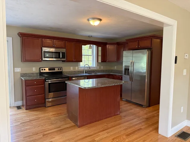 a kitchen with stainless steel appliances granite countertop a refrigerator and a stove