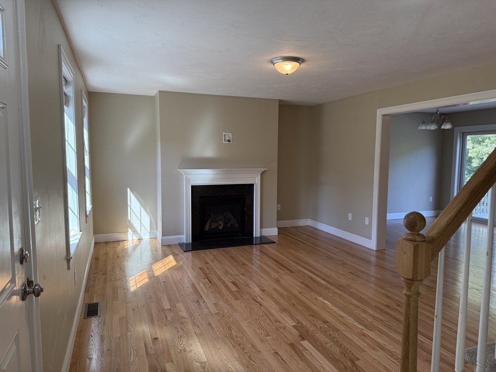 87 Center Street Carver, MA 02330 - Photo 7 of 42 a view of empty room with wooden floor and fireplace