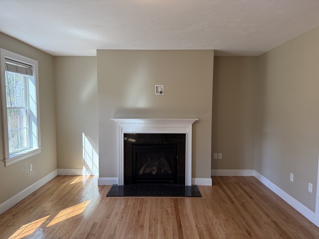 87 Center Street Carver, MA 02330 - Photo 9 of 42 a living room with a fireplace and wooden floor