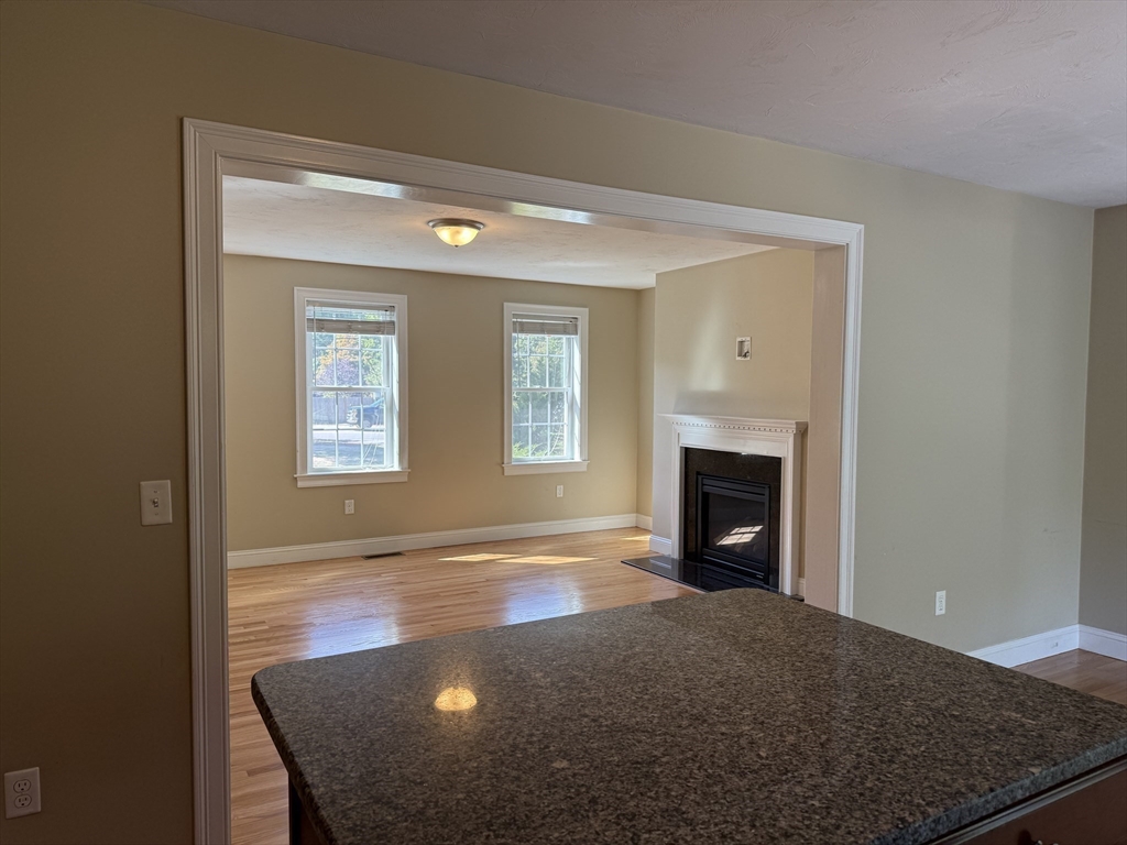 87 Center Street Carver, MA 02330 - Photo 10 of 42 a view of a livingroom with a fireplace a sink and dishwasher