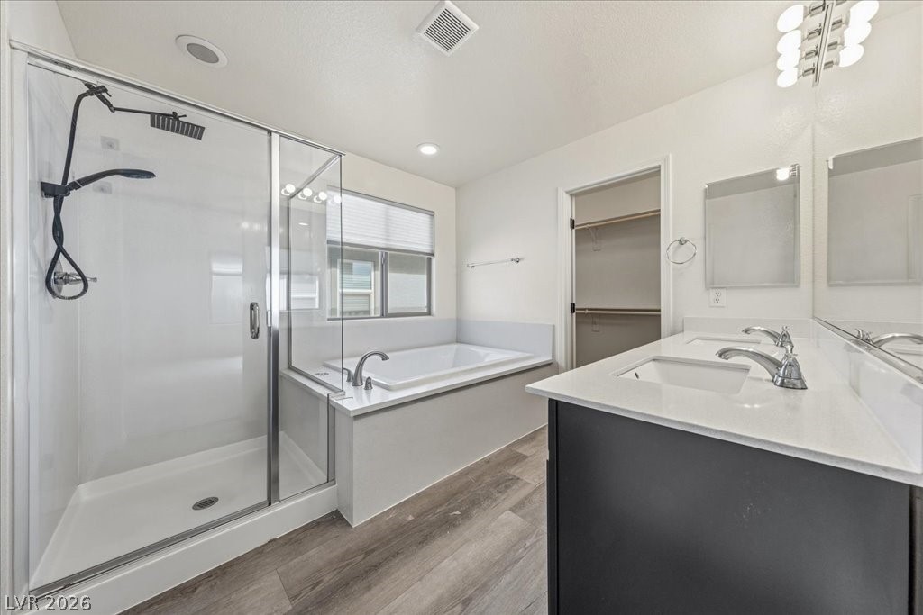 290 Cape Seville Place Henderson, NV 89015 - Photo 18 of 50 Luxurious primary bathroom with separate soaking tub and large walk-in shower, plus double vanities.