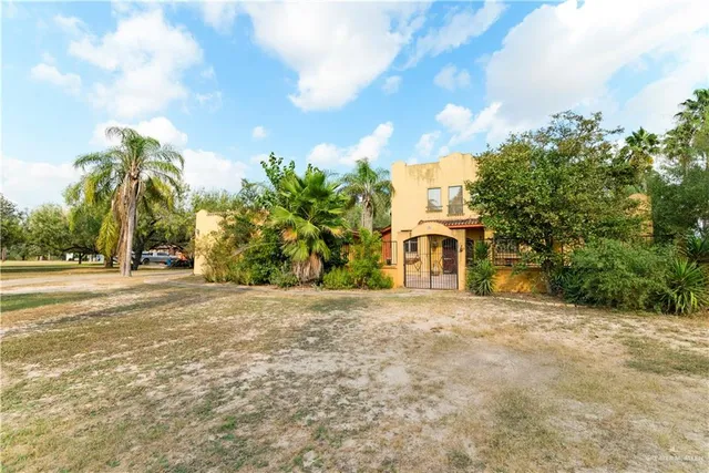 a front view of a house with a yard and trees