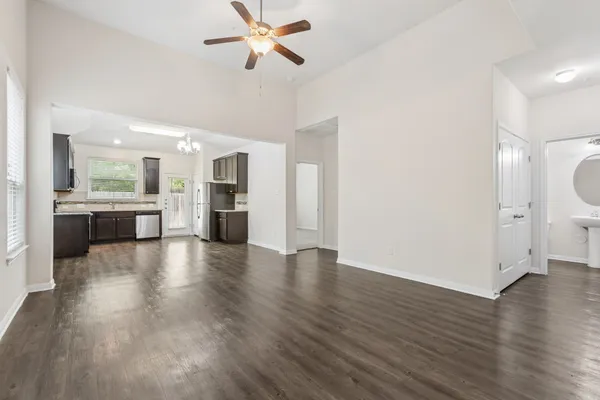 a view of a kitchen with a fridge wooden floor and a kitchen