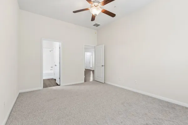 a view of an empty room with a ceiling fan